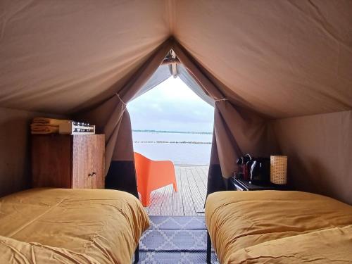 a bedroom with two beds in a tent at Safaritent 2 in Biddinghuizen