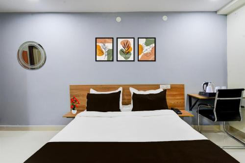 a bedroom with a white bed and a table and chairs at Super Townhouse Kukatpally North Formerly Munagala Arcade in Hyderabad
