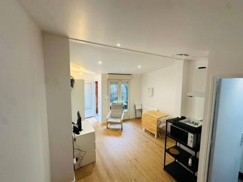 een woonkamer met een tafel en een bureau in een kamer bij Neuf lumineux et agréable en rdc avec terrasse - 33 in Dax