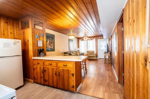a kitchen and living room with wooden walls and a refrigerator at Atlantic Winds Condos in Myrtle Beach