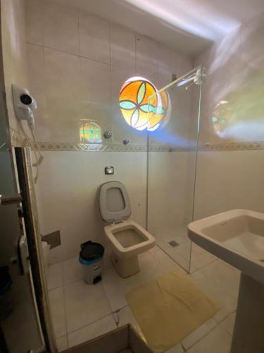 a small bathroom with a toilet and a sink at Pousada Tamboril in Brumadinho