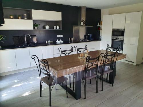 une cuisine avec une grande table et des chaises en bois dans l'établissement Maison moderne, à Marguerittes