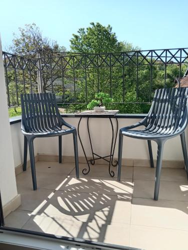 two chairs and a table on a balcony at Apartmani Slatinska Oaza in Vrnjačka Banja