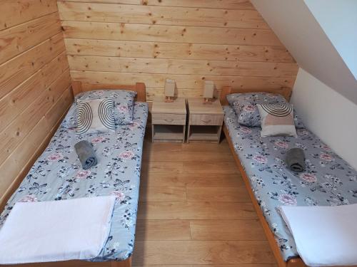 a room with two beds and a table at Między Górami in Korbielów