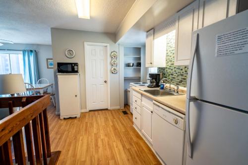 a kitchen with a refrigerator and a sink at Atlantic Winds Condos in Myrtle Beach