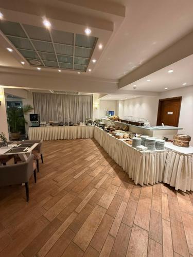 a large room with tables and a buffet in a building at Aeolis Hotel in Samos
