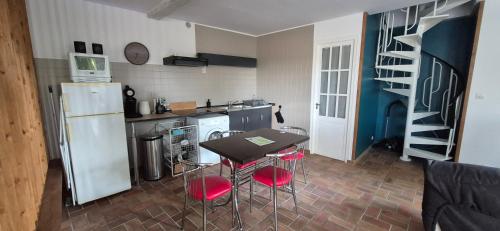une cuisine avec une table, des chaises et un réfrigérateur dans l'établissement Clarallen, à Saint-Vaury