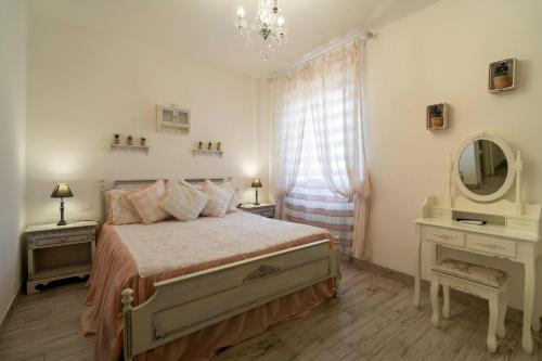 a bedroom with a bed with a mirror and a window at Agriturismo Corte degli Angeli in Marina di Grosseto
