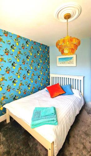 a bedroom with a bed with a blue wall at The Edwardian in Brighton & Hove