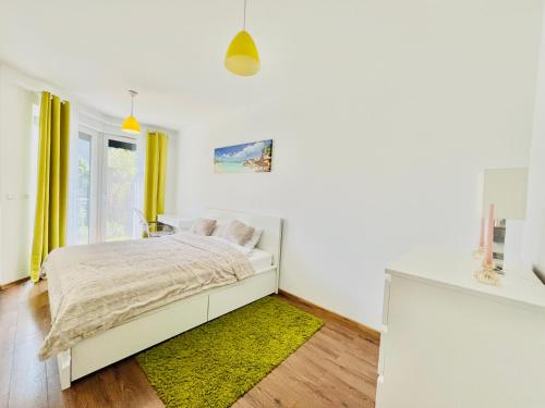una camera bianca con un letto e un tappeto verde di Bronowice Residence Blue - Homey Apartment with Garden and Parking a Cracovia