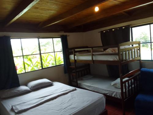 een slaapkamer met 2 stapelbedden en 2 ramen bij La Puerta de Malacatiupan in Atiquizaya