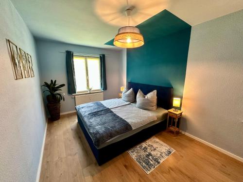 a bedroom with a bed with a blue wall at Barrierefrei und Hunde willkommen Hohe Gäste in Naumburg