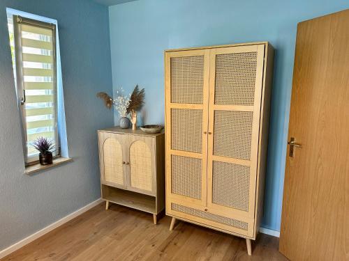 a room with a wooden cabinet next to a window at Barrierefrei und Hunde willkommen Hohe Gäste in Naumburg