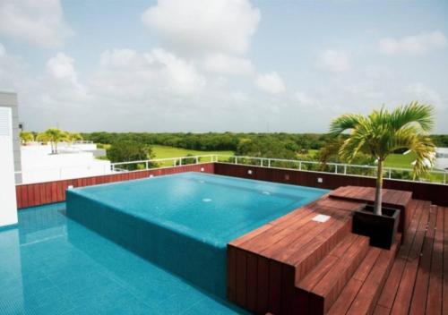 a swimming pool on the roof of a building at Apartment with Private Terrace, Pool and Beach Club Access in Playa del Carmen