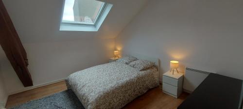 - une chambre avec un lit, une fenêtre et 2 lampes dans l'établissement Séjour de caractère, à Château-Thierry