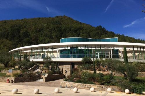 un grand bâtiment avec une montagne en arrière-plan dans l'établissement Les Naïades I51- 2 bedrooms for 5 people !, à Avène