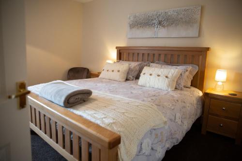 a bedroom with a large bed with a wooden headboard at Business Bliss Stays in Dufton