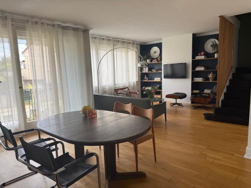un salon avec une table et des chaises de salle à manger dans l'établissement maison d'Adrien et Mathilde, au Mans