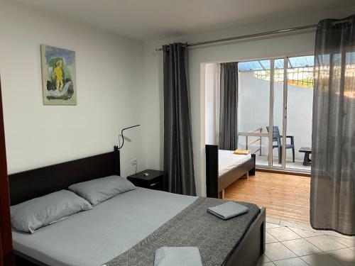 una habitación con cama y vistas a un balcón en Duplex on Fifth, en Sarandë