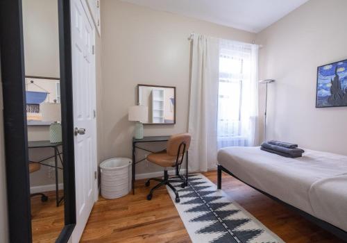 a bedroom with a bed and a desk and a chair at Sunny 4BR/2BA Retreat in Morningside Heights, NYC in New York