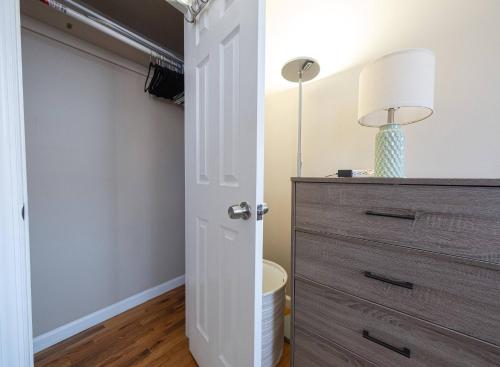 a bedroom with a closet with a dresser and a lamp at Sunny 4BR/2BA Retreat in Morningside Heights, NYC in New York