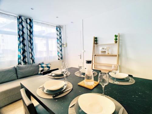 une salle à manger avec une table avec des assiettes et des verres à vin dans l'établissement Superb Apartment with Parking Amboise 1, à Vannes
