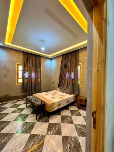 a room with a bed and a checkered floor at Villa Zine in Aït Namous