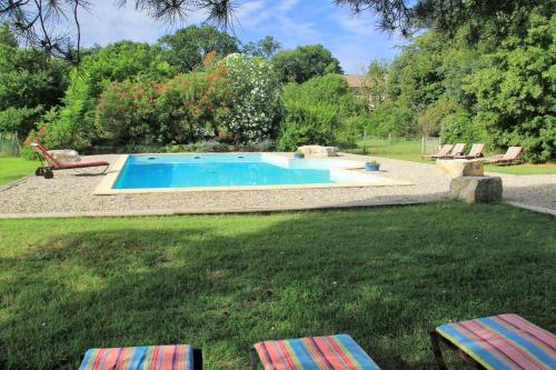 - une piscine dans une cour avec 2 chaises dans l'établissement Gîtes à la ferme du Bosquet, à Saint-Didier-sous-Aubenas
