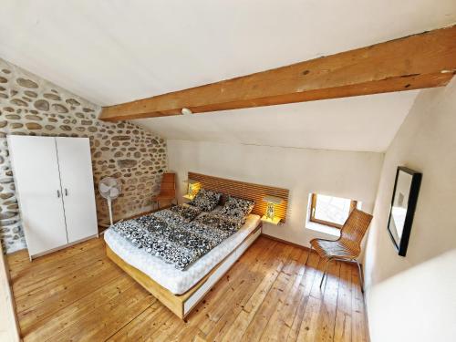 - une chambre mansardée avec un lit et du parquet dans l'établissement Gîtes à la ferme du Bosquet, à Saint-Didier-sous-Aubenas