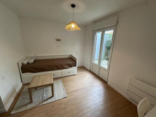 een slaapkamer met een bed en een tafel erin bij Appartement tout neuf avec patio - 31 in Dax