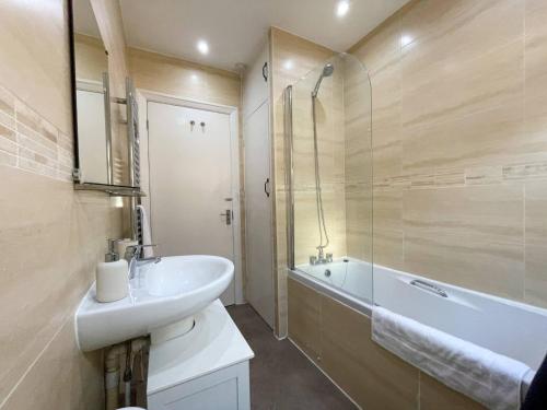 a bathroom with a sink and a bath tub and a sink at 3-bed Chelmsford apt w garden in Chelmsford