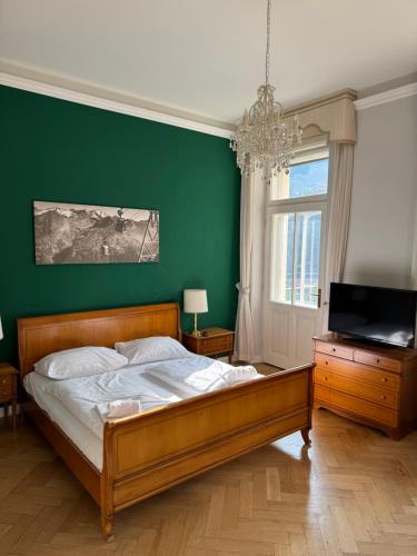 a bedroom with a bed and a green wall at Grand Hotel de l Europe in Bad Gastein