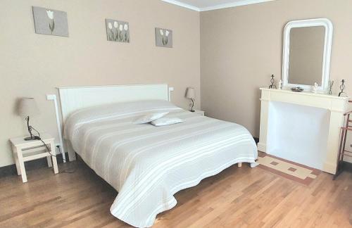 une chambre avec un lit blanc et un miroir dans l'établissement Lou Caussinhol 3 épis, à Montbazens