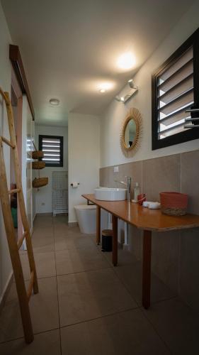 a bathroom with a wooden table and a sink at Galanterie in Grand-Bourg