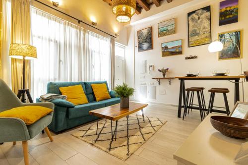 a living room with a blue couch and a table at Exclusive Boutique in Jerez de la Frontera