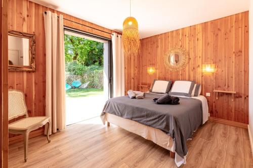 une chambre avec un lit et une grande fenêtre dans l'établissement Luxury 6BR Villa with Heated Pool, Playground, Garden, à Lège-Cap-Ferret
