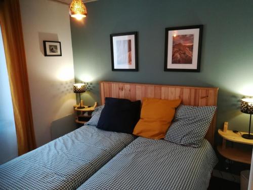 - un lit avec des oreillers bleus et orange dans une chambre dans l'établissement Maison de village, à Campan