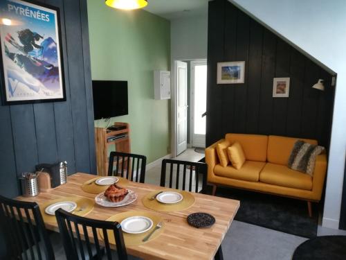 un salon avec une table et un canapé dans l'établissement Maison de village, à Campan