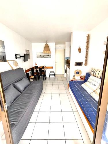 une chambre avec un lit et un salon dans l'établissement Appartement familial et pratique, au Barcarès