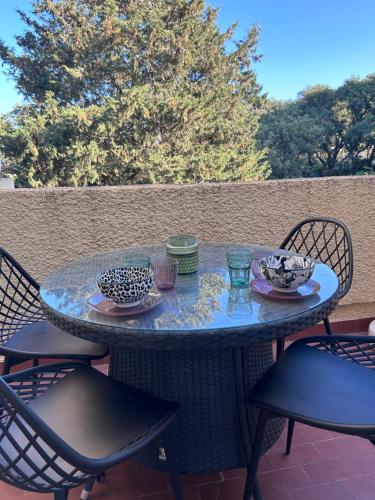 une table de patio avec des chaises et un bleu dans l'établissement Studio résidence saint loup- particulier, au Cap d'Agde