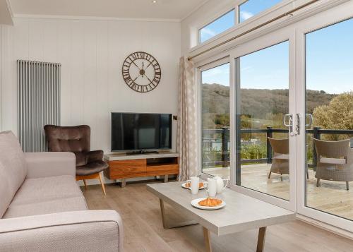 a living room with a couch and a tv at Cheddar Woods Resort And Spa in Cheddar