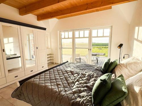 een slaapkamer met een bed en een groot raam bij Villa Neufunnixsiel in Neufunnixsiel