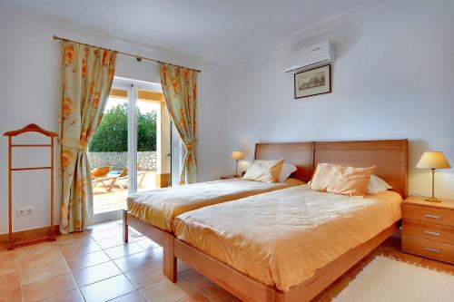 a bedroom with a large bed and a balcony at Casa Alha in Carvoeiro