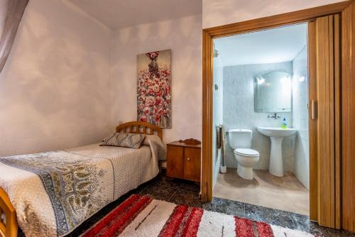 a bedroom with a bed and a sink and a toilet at Villa Solente in Benalúa de las Villas