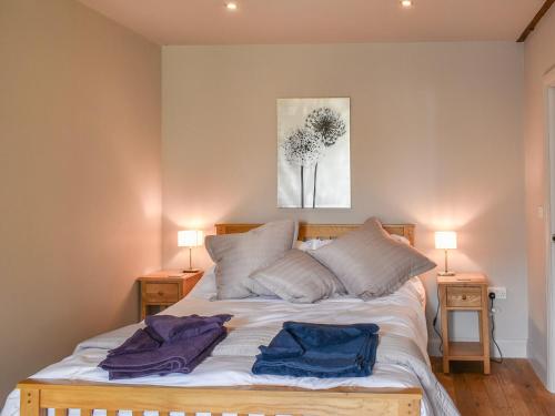 a bedroom with a bed with two towels on it at The Old Paybarn - Uk39378 in Snettisham