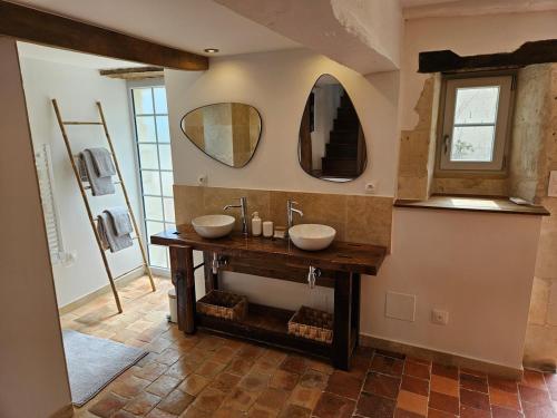 a bathroom with two sinks and two mirrors at Cottage de la Plante in Thuré