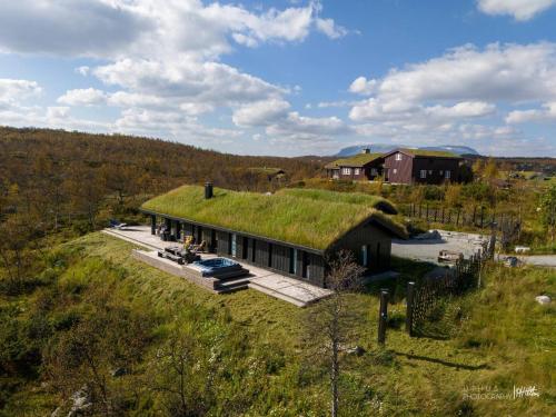 a house with a grass roof on top of it at Nydelig og Moderne hytte på Kikut Geilo - 6 senger, 4 soverom og jacuzzi in Geilo