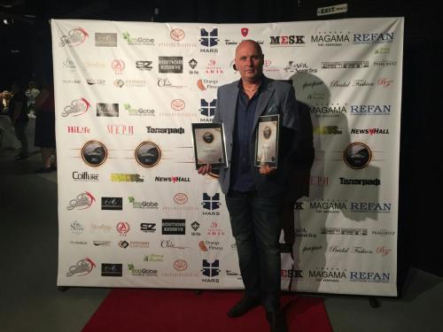 a man is holding an award on a red carpet at Hotel Adria in Sofia