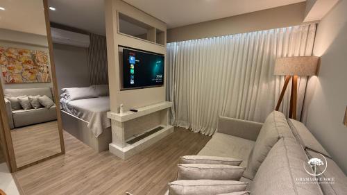 a living room with a couch and a television at Modern apt next to Criamigos Park + coffee Day 1 in Gramado