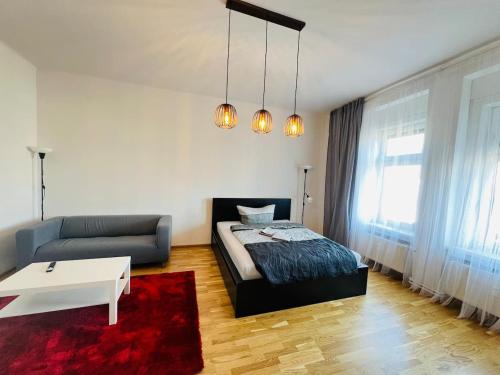 a bedroom with a bed and a couch and a table at Living Graz Eggenberg Top 17 in Graz